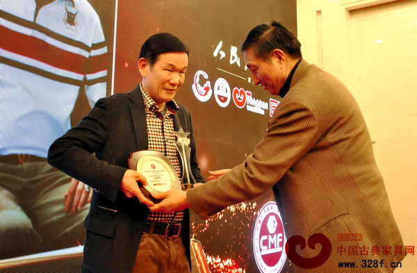 区胜春从故宫专家曹静楼手中接过风云人物奖杯