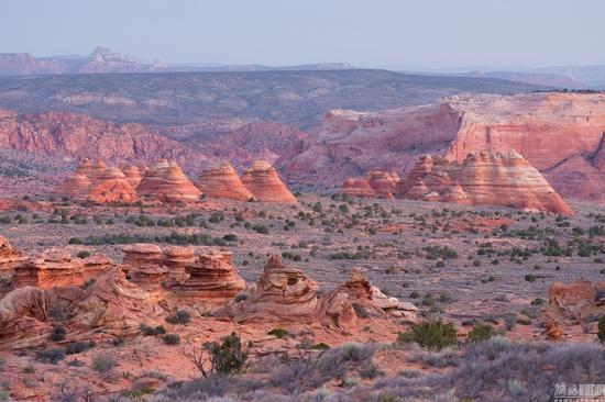 当地时间2016年3月,美国,摄影师David Clapp走访亚利桑那州、犹他州、内华达州和新墨西哥州拍摄美国西南部的沙漠荒地,看起来像外太空景观十分惊艳。图为当地时间2016年3月,美国亚利桑那州,一男子晚间站在岩石上拿着手电筒照向银河系。