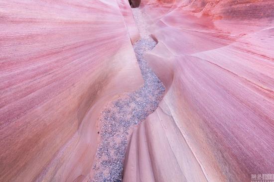 当地时间2016年3月,美国,摄影师David Clapp走访亚利桑那州、犹他州、内华达州和新墨西哥州拍摄美国西南部的沙漠荒地,看起来像外太空景观十分惊艳。图为当地时间2016年3月,美国亚利桑那州,一男子晚间站在岩石上拿着手电筒照向银河系。