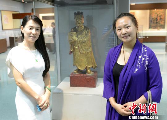 二名女性观众与展品合影留念。 记者刘可耕 摄